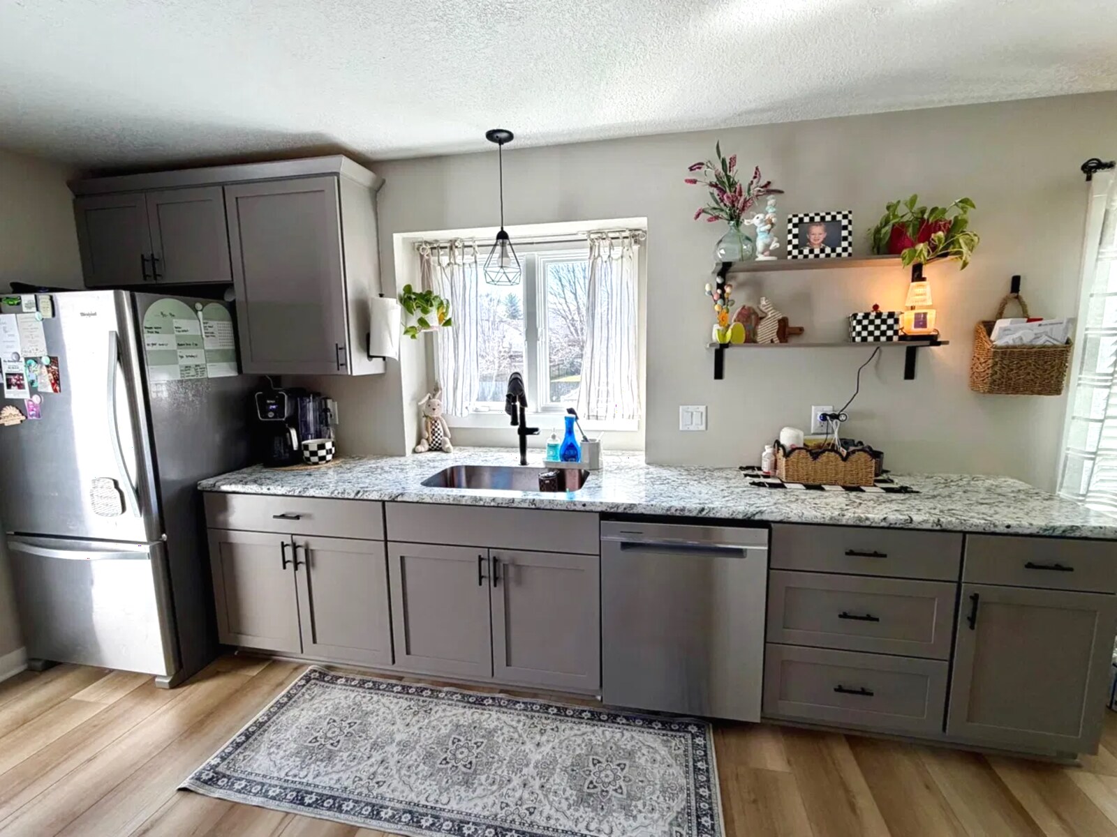 Kitchen with gray shaker cabinets, granite countertops, and stainless appliances